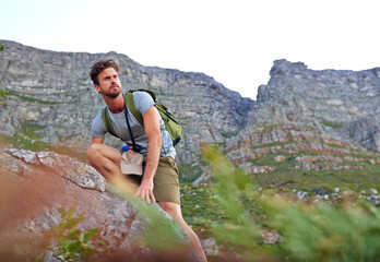 Looking towards the destination. a handsome young man scaling a mountain.