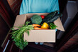 Home fresh food delivery. Woman holding cardboard box with vegetables and fruits. Support local farmer food production. New Start of a healthy life, weight loss concept. Online food order. Recipe box.