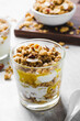 Granola and Yogurt Parfaits, Healthy Breakfast or Snack, Muesli with Nut Mix and Honey on Bright Concrete Background