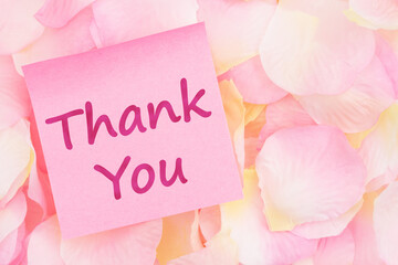  Thank you message on a pink sticky note with pink and yellow rose petals