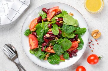 Red Bean Salad On Bright Background, Fresh Salad with Spinach, Cherry Tomatoes, Walnuts, Beans and Mustard Dressing