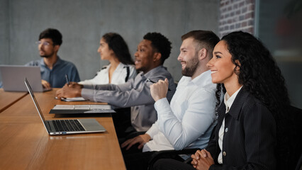 Multiracial office workers watching presentation webinar online video conference in boardroom multiethnic employees partners coworkers smiling listening lecture corporate studying company interview