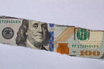 100 US dollar banknote in torn paper hole