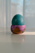 pastel blue colored easter egg on a table, vertical