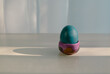pastel blue colored easter egg on a table with shadow