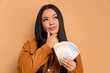 © Vergani Fotografia - serious african american woman with brazil banknotes currency in all beige colors. business, loan, pay, wealth concept. 