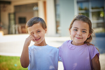 Sticker - Time to play. Portrait of a young brother and sister standing together outside their house.