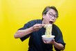 Happy attractive asian man with peek a boo hair eats noodles on bowl with chopstick