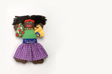 Wall Mural - Rag doll, black doll in Caribbean style and colorful dress, isolated on white background, space for text