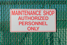 Maintenance Shop Authorized Personnel Only Street Sign Against An Industrial Fence