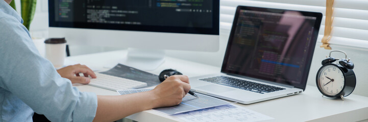 Wall Mural - programmer writing program code with two monitors and working on a new software or hacker programmin