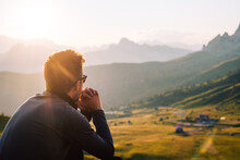 Person Mit Sonnenbrille Sitzt In Den Bergen Bei Sonnenuntergang Und Genießt Die Natur 