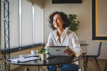 Wall Mural - One woman mature female entrepreneur use digital tablet for work