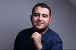 © Arvin - hombre profesional con camisa azul sonriente frente a un fondo blanco