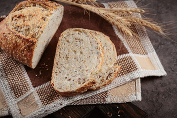 Wall Mural - Sliced fresh baked whole grain bread with oats, flax seeds and sesame seeds on rustic wooden board. Bakery products