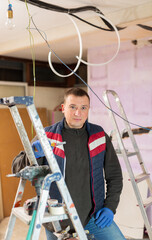 Wall Mural - Positive repair man standing in apartment, smiling and looking at camera.