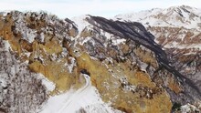 Giant Rock Gate Formation And Snowy Slopes With Bare Trees