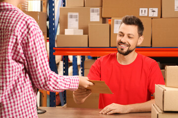 Canvas Print - Woman receiving parcel from worker at post office