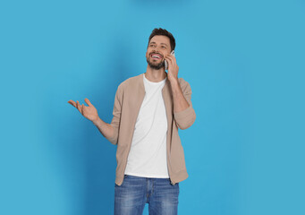 Poster - Man talking on phone against light blue background