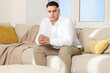 © New Africa - Attractive groom on sofa indoors. Wedding preparation