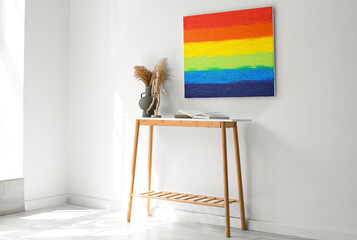 Poster - Table with vase, mannequin, books and painting of LGBT flag on light wall