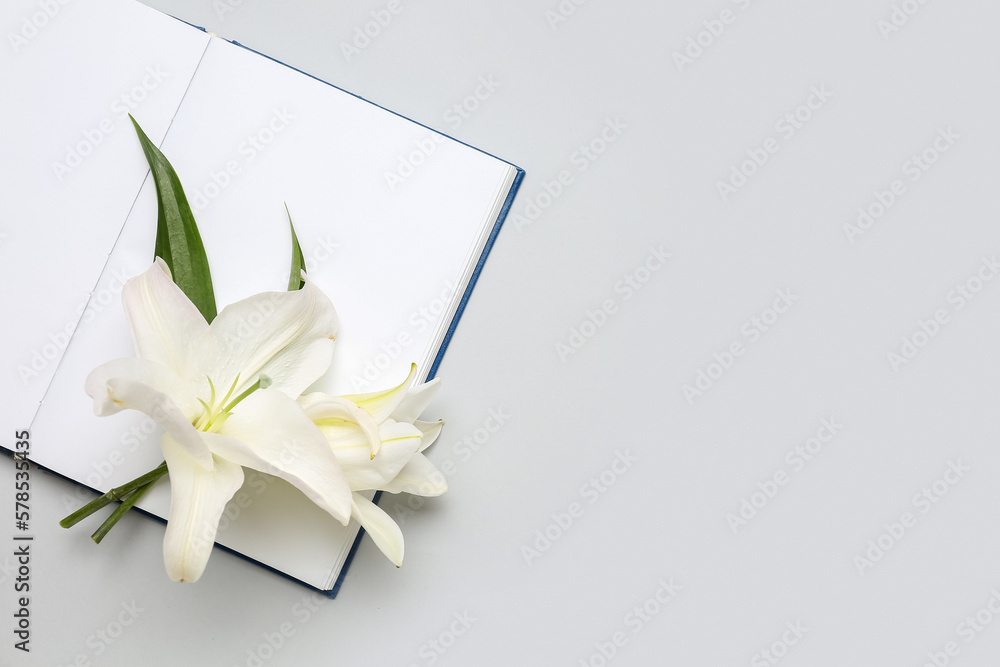 Open book and beautiful lily flowers on white background