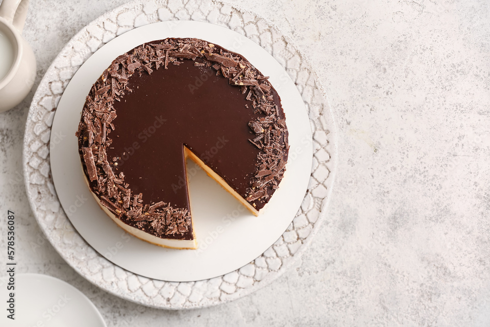 Plate with tasty birds milk cake on light background