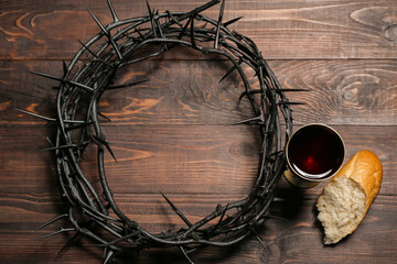 Wall Mural - Crown of thorns with cup of wine and bread on wooden background