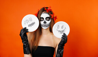 Wall Mural - Photo of a girl in Halloween makeup and flower holding some Halloween cartoons.