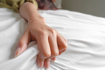 A photo of a man and woman's hands having sex on a bed. make love.