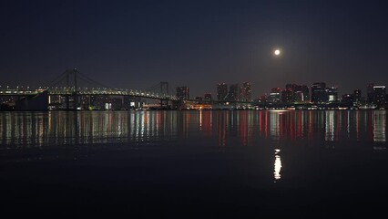 Wall Mural - Wide angle 4K night video with Rainbow Bridge architecture landmark from Tokyo under full moon sky. Travel to Japan.