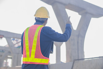 Wall Mural - Construction Engineer using computer inspection on site highway road construction, Construction worker using laptop