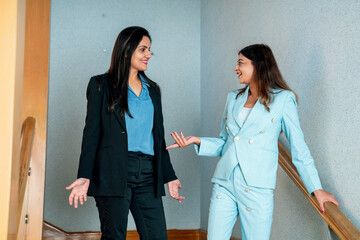 Canvas Print - Two indian Corporate woman talking each other some subject at office