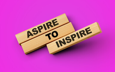 Aspire To Inspire Text On Wooden Blocks Isolated On Magenta Background, 3d illustration