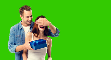 Love, dating, celebrating, lovers concept - happy amorous couple with blue gift box, isolated green chroma key background.