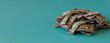 © RocknRoller Studios - Banking Banner with Fifty Dollar Bills. Pile of Cash Bundles on Aqua surface with copy-space.
