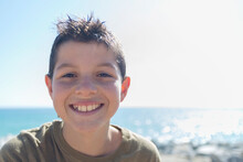 Close Up Portrait Of Young Boy In A Sunny Day While Smiling