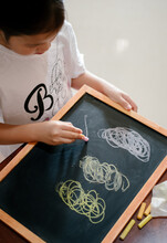 Girl Drawing On Black Board