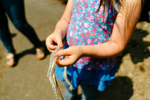 Cropped Image Of A Young Girl Holding A Found Snake Skin