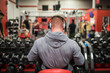 © Cavan Images - Fit man preparing to lift dumbbells at the gym