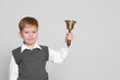 © New Africa - Pupil with school bell on light grey background. Space for text