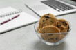 Chocolate chip cookies on light gray table in office, closeup. Space for text