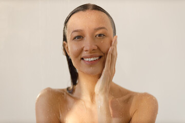 Wall Mural - Young woman under the trickles of water in pleasure shower. Beautiful girl under the spray of water. Wet happy face