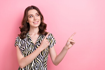 Sticker - Photo of positive young lady curly hairstyle look empty space direct fingers deal advert old school clothes store isolated on pink color background