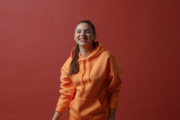 Wall Mural - Young positive smiling woman in orange fitness sport outfit cloth dancing.