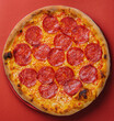 © AntAlexStudio - Fresh tasty pizza with pepperoni on red background