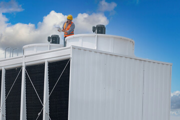 Wall Mural - Industry engineer under checking the industry cooling tower air conditioner is water cooling tower air chiller HVAC of large industrial building to control air system.