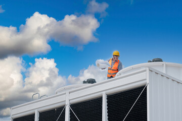 Wall Mural - Industry engineer under checking the industry cooling tower air conditioner is water cooling tower air chiller HVAC of large industrial building to control air system.