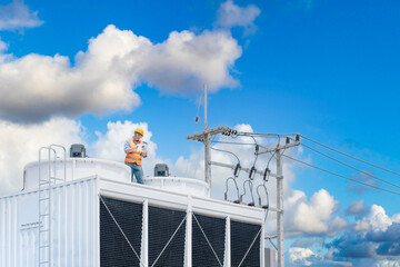 Wall Mural - Industry engineer under checking the industry cooling tower air conditioner is water cooling tower air chiller HVAC of large industrial building to control air system.