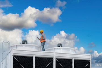 Wall Mural - Industry engineer under checking the industry cooling tower air conditioner is water cooling tower air chiller HVAC of large industrial building to control air system.